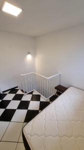 Ce lit se trouve dans une chambre dotée d'un sol en damier. dans l'établissement Check and Home - Casa San Luis - 6 Huéspedes en Barrio Chauvin, à Mar del Plata 4 autres photos