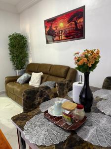 a living room with a couch and a table with flowers at Nabs lodge in Kumasi
