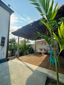 a patio with a wooden deck with a roof at Suítes Cabanas Coral in Serra