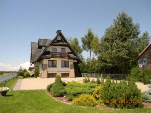 una casa grande con tejado abuhardillado en Szymkówka, en Nowa Biała