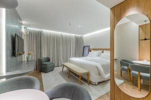 a hotel room with a bed and a table and chairs at Batel Luxury - Próx Pátio Batel in Curitiba