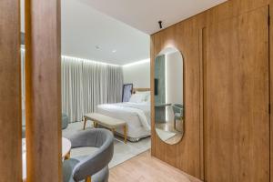 a hotel room with a bed and a mirror at Batel Luxury - Próx Pátio Batel in Curitiba