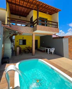 a swimming pool in front of a house at Casa Amarela Milagres in São Miguel dos Milagres