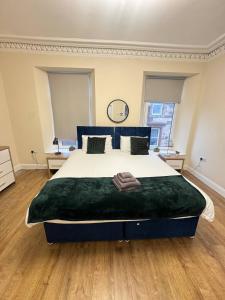 Un dormitorio con una cama grande con una manta verde. en Apartment 3- 216 high Street, en Arbroath