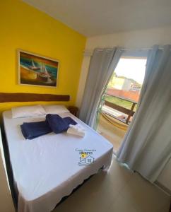 a bedroom with a white bed with a window at Casa Amarela Milagres in São Miguel dos Milagres