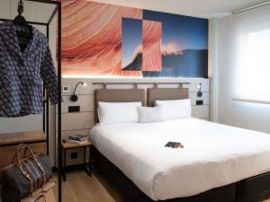 1 dormitorio con 1 cama con una gran sábana blanca en ibis Styles Santander, en Santander