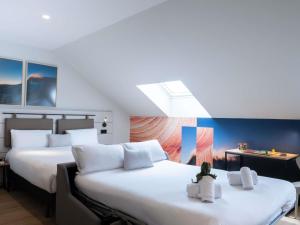 um quarto de hotel com duas camas com travesseiros brancos em ibis Styles Santander em Santander mais 101 fotografias