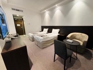a hotel room with two beds and a television at Cent Al Azizia Hotel Makkah in Mecca