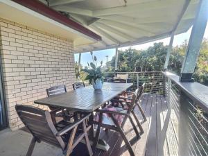 a wooden table and chairs on a patio at Vista at Straddie View in Dunwich +43 photos
