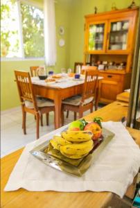 einen Teller Bananen und andere Früchte auf dem Tisch in der Unterkunft Casa do Reiki - Terapias & Aconchego na Natureza in Rancho Queimado