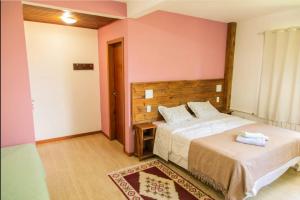 ein Schlafzimmer mit zwei Betten und rosa Wänden in der Unterkunft Casa do Reiki - Terapias & Aconchego na Natureza in Rancho Queimado