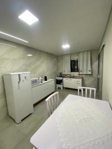 una cucina con un tavolo e un frigorifero bianco di Recanto do Sol a Governador Celso Ramos