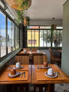 a restaurant with wooden tables and straw hats on them at Pousada Grão & Vinha in Espirito Santo Do Pinhal
