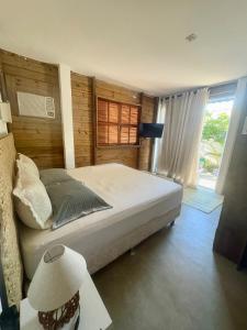 a bedroom with a large bed and a window at Suítes Cabanas Coral in Serra