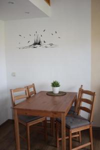 einen Holztisch und Stühle mit einer Pflanze an der Wand in der Unterkunft Ferienwohnung Alte Brennerei in Brösa