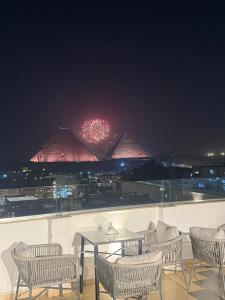Un patio con mesa y sillas y fuegos artificiales. en Casa De Pyramids, en El Cairo