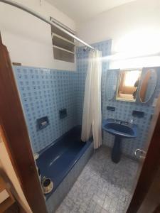a bathroom with a blue tub and a sink at Departamentos Tala y Tuyú in San Clemente del Tuyu
