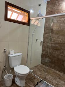 a bathroom with a toilet and a glass shower at Pousada Estância Mineira in Guapé +29 photos