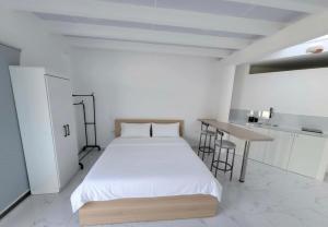 a white room with a bed and a table at Suite Samborondón in SamborondÃ³n +8 photos