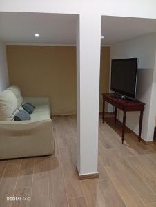 a living room with a couch and a tv and a table at villa del mare in Nettuno