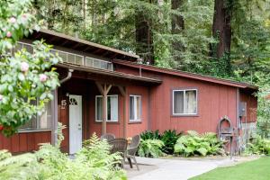 a red house with chairs in front of it at Fern River Resort in Felton