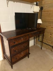 a wooden dresser with a television on top of it at Suítes Cabanas Coral in Serra