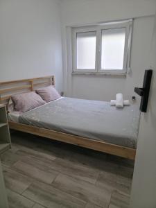a bed in a room with a window at Nok Nok in Odivelas
