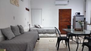 een woonkamer met een bank en een tafel bij Departamento temporario Banda para 4 personas a 5 min del estadio madre de ciudades y del nodo tecnologico in La Banda