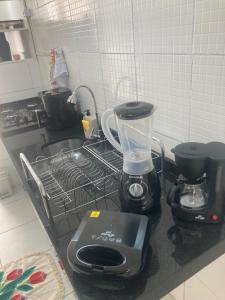 a kitchen counter with a blender and a sink at Descanse perto do aeroporto e Conheça Maceió - 24h in Maceió
