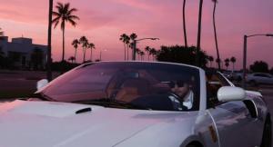 a man driving a white car in a parking lot at Full Service Caravan 4 in Albertslund