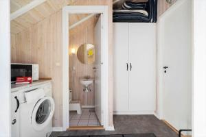 a bathroom with a washing machine and a sink at 364-Hvide-Sande-Fyrmarken-34 in Hvide Sande +35 photos