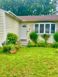 a white house with a door and a yard at Just like home in West Babylon