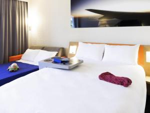 a hotel room with a large white bed with a tray on it at ibis Styles Marseille Aéroport in Vitrolles