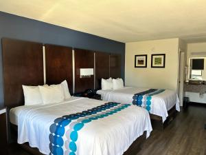 a hotel room with two beds with blue and white covers at GuestHouse Inn Dothan in Dothan
