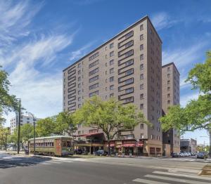 a tall building on a city street with a trolley at Club Wyndham Avenue Plaza in New Orleans