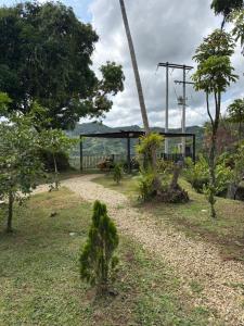 a garden with trees and a gazebo in the background at Jaragual EcoHostel in La Vega +36 photos