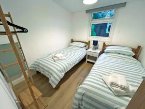 2 camas en una habitación pequeña con una escalera en Elmrise View, en Llanstephan