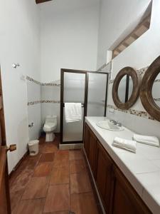 a bathroom with a toilet and a sink and a mirror at Finca La Maria - Filandia in Quimbaya +16 photos