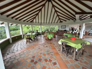 a dining room with tables and chairs in a pavilion at Finca La Maria - Filandia in Quimbaya