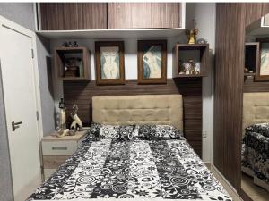 a bedroom with a bed with a black and white comforter at Lar dos Fernandes in Belém