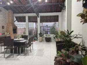 a dining room with a table and chairs and plants at Lar dos Fernandes in Belém