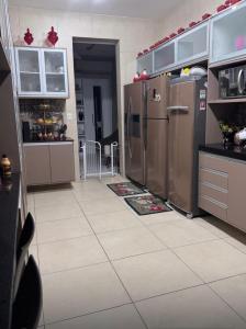 a kitchen with stainless steel appliances and a tile floor at Lar dos Fernandes in Belém