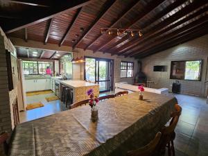 ein Esszimmer mit Tisch und eine Küche in der Unterkunft Recanto Don Ciro in Uruguaiana