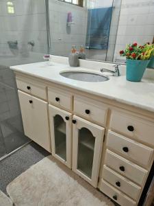 ein Bad mit Waschtisch, Waschbecken und Spiegel in der Unterkunft Recanto Don Ciro in Uruguaiana