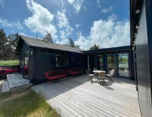 a deck with chairs and a table on a house at 3398-Hvide-Sande-Anker-Eskildsens-Vej-100 in Hvide Sande