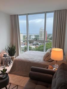 a bedroom with a bed and a large window at Charlotte Belgrano Posadas in Posadas +36 photos