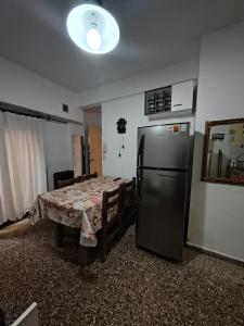 サンベルナルドにあるDepto 2 amb San Bernardoのキッチン(テーブル、冷蔵庫付)が備わります。