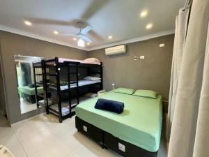 a bedroom with a bed and a bunk bed with a window at Casa Praia e hostel in Praia Grande