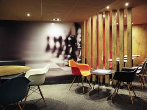 a restaurant with tables and chairs and a painting at ibis Montpellier Centre Comedie in Montpellier