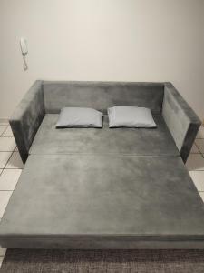 a large couch with two pillows on it at Apartamento em Cacoal - centro in Cacoal